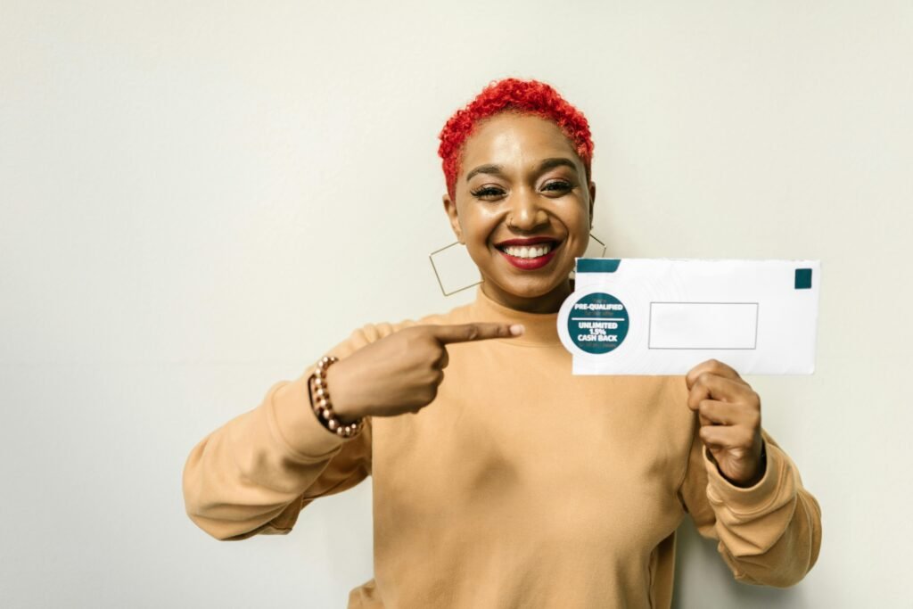 Cheerful woman pointing at an envelope with a cashback offer, emphasizing financial benefits.